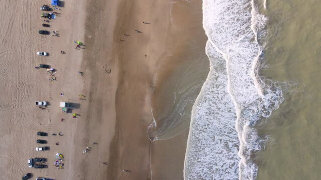 Static top down drone shot of a beach in Caril&oacute;, Argentina with waves crashing on the shore.