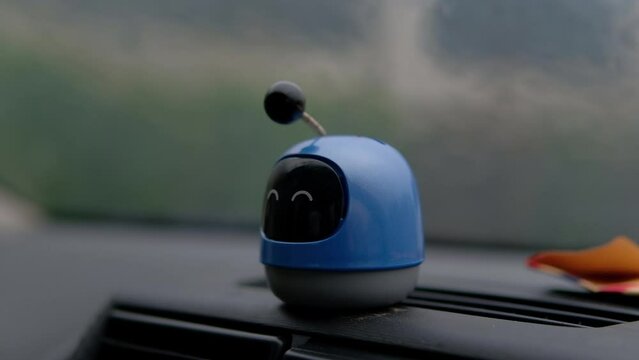 Plastic figure toy on car dashboard