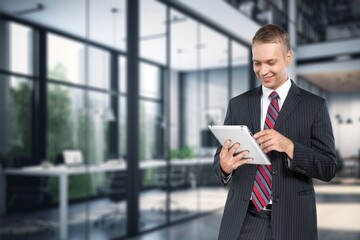 Handsome young businessman works on digital tablet in the office