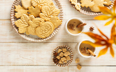 Autumn table scene with spiced halloween cookies. Top view on a rustic wood background.