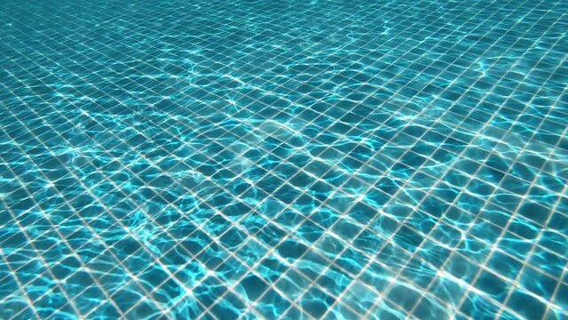 diving into the water on blue swimming pool, beautiful pool texture background, slow motion scene