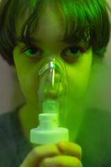 the child does inhalation, the boy inhales the medicine through the mask