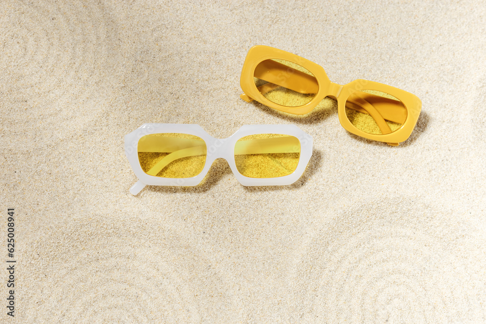 Poster stylish white and yellow sunglasses on sand background at sunlight, summer fashion collection eyegla