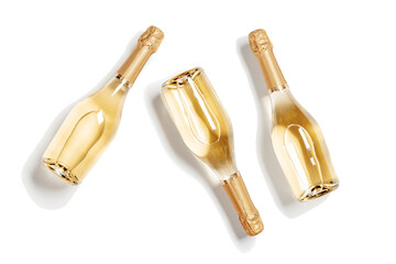 Fototapeta premium Three bottles of white sparkling wine, set full glass champagne bottles close up, isolated on white background, cutout design object, sunlight, Summer alcoholic drinks rose wine, top view