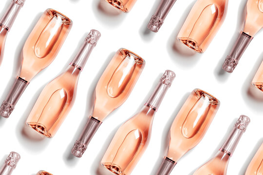 Trend Aesthetic pattern of bottles of rose sparkling wine, glass champagne bottles, isolated on white,  sunlight shadow. Summer Romance festive drink concept. Summer alcohol drinks background
