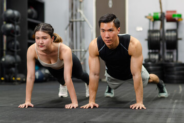 Obraz na płótnie Canvas Millennial Asian strong young male and female muscular fitness model athlete couple in sexy sport bra and legging planking bodyweight workout on floor exercise training ready to pushing up in gym