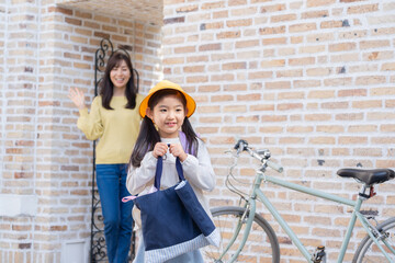 登校する小学生1年生と見送るママ（育児・子育て）