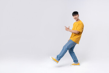 Full length of a handsome asian man pointing out to present something, the smile on his face, his hand gesture and the casual outfit are perfect for the suggestion to copy space.