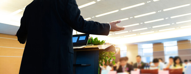 Business man making a speech in front of big audience