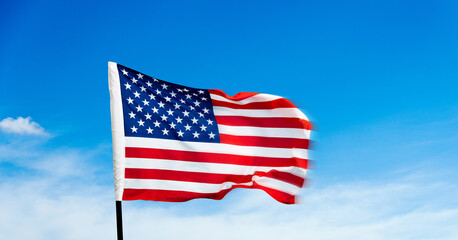 Obraz premium American flag waving on blue sky background