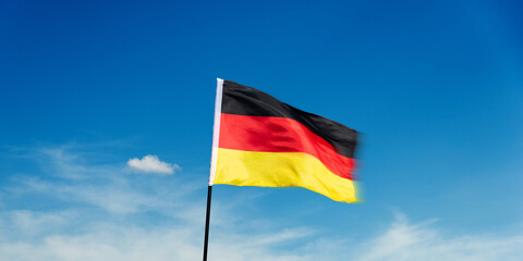 German flag waving against blue sky background