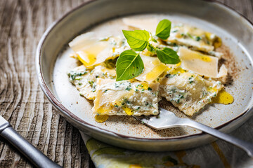 Ravioli with ricotta cheese, parmesan and spinach. Garnished with basil leaves and olive oil. Fresh and tasty classic Italian pasta dish.