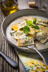 Ravioli with ricotta cheese, parmesan and spinach. Garnished with basil leaves and olive oil. Fresh and tasty classic Italian pasta dish.