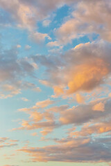 Beautiful fluffy clouds painted in bright painterly colors at sunrise. Multicolor vertical background or wallpaper