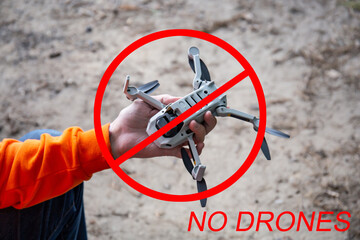 Ban drones. Quadcopter aerial photography is prohibited. No-fly zone for drones. A man holds a...
