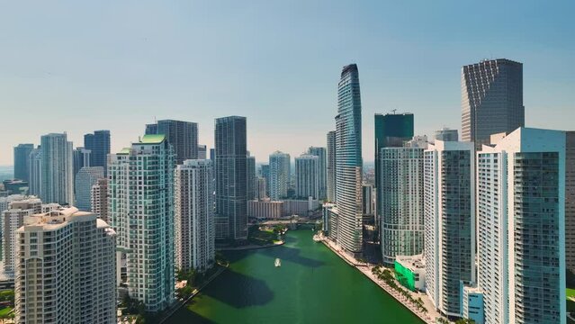Miami city downtown with luxury yachts on Miami River between concrete and glass skyscraper buildings in Florida, USA. Urban landscape of modern american megapolis