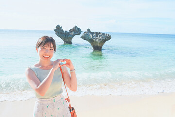 沖縄の古宇利島ハートロックで観光する女性