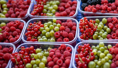 Heap of raspberry, red currant and gooseberry in market