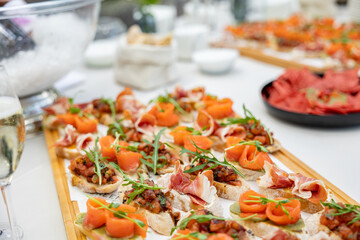 Bruschetta snacks, cheese with sausages, pate. A festive table for a company of people with many different dishes.