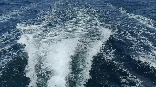 Water trail from a motor boat. View of the waves diverging from the speedboat.