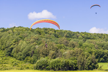 Paraglider come in for landing at a field