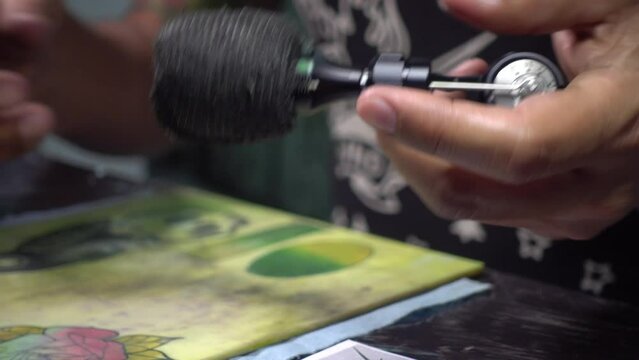 Close-up shot of a tattoo artist getting his tools ready for the next session