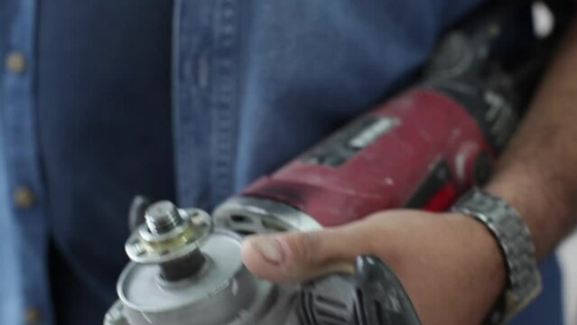 Close-up shot of a worker changing the pad on a machine polisher