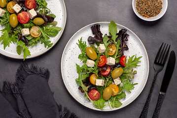 Food photography of  feta salad; vegetable; tomato; olive; lettuce; spinach, rocket, mizuna, cheese; leaf; organic; ingredients; slice; vitamin; vegetarian; diet