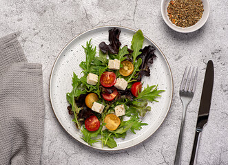 Food photography of  feta salad; vegetable; tomato; onion; lettuce; spinach, rocket, mizuna, cheese; leaf; organic; ingredients; slice; vitamin; vegetarian; diet