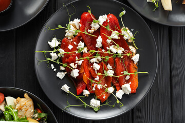 Baked bell pepper salad with feta cheese, vegetable salad background, top view
