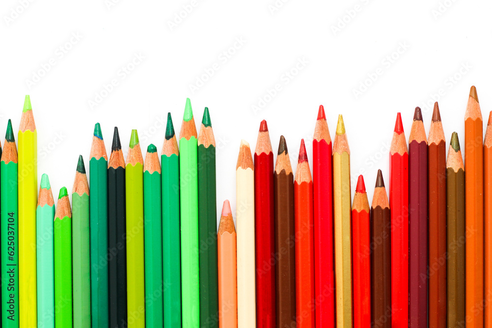 Wall mural Multi-colored pencils lie on a white table, the green range of colors.