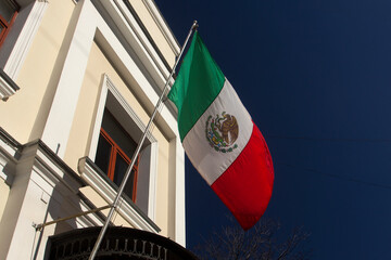 Mexican national flag. Bandera de México. Mexican flag hanging from a flagpole. Mexican flag at the Mexican Embassy in Moscow. Close up. Bottom up view.