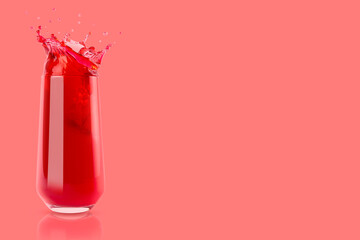 Cherry red cool juice in glass with reflection, juicy splashes and drops fly on pastel pink background, copy space. Ripe summer fruit drink with bubbles, swirl and splashing.