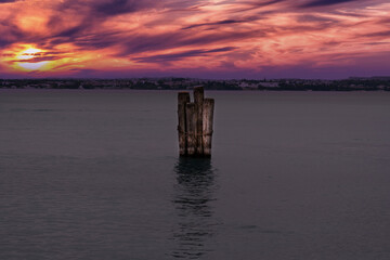 Fototapeta na wymiar wooden palisade in lake garda at sunset