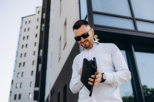 Stressed And Broke Millennial Asian Businessman Opening His Empty Wallet In The City. Bankrupt, Financial Problem, Failure.