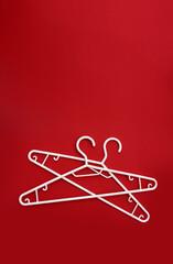 two white hangers on a red background with copy space in a minimalist style. Fashion women blog template for social media, sale, shop, promo design, shopping concept