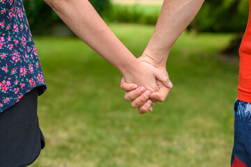 Para na spacerze, trzymająca się za ręce 