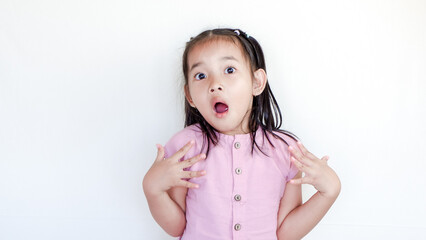 Surprised beautiful little child girl in casual looking to camera on light color background. Human...