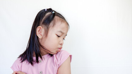 Over the shoulder view of cute young girl looking away her face on light color background.