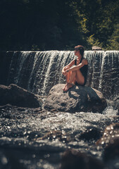Junge Frau im Urlaub am Wasserfall
