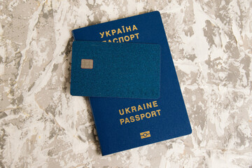 Passport of a citizen of Ukraine and a modern credit bank card with a chip on a light table. The...