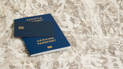 Passport of a citizen of Ukraine and a modern credit bank card with a chip on a light table. The concept of increasing cases of fraud in Ukraine.
