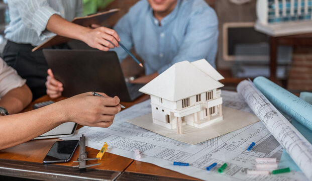 Concepts Architecture and engineer, Engineering, Design, Planning. Businessman and architech meeting for planing and checking house design and house model and secretary takes notes meeting.