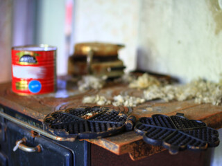 Cast waffle iron left on a rusty stove in abandoned house