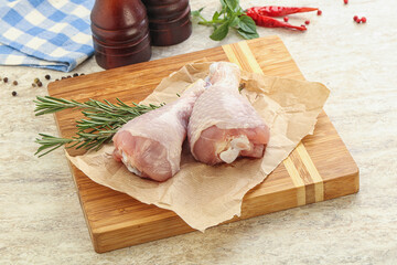 Raw chicken leg over board