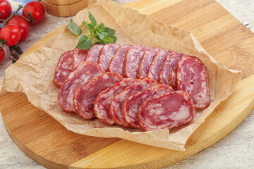 Sliced salami sausages over board