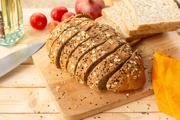 Sliced bread with sesame seeds on wooden cutting board.