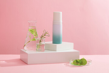Against the pink background, a blank bottle container cosmetic placed on white podiums with glassware filled with seaweed leaves. Space for design, advertising and branding cosmetic product