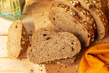 Whole wheat bread with sesame seeds on a wooden background.