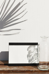 Frame mock up against a concrete wall, transparent vase and beautiful shadows.